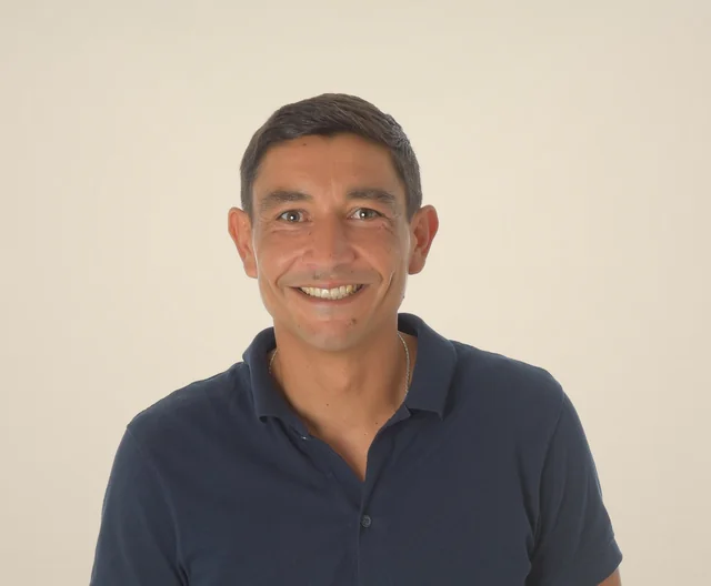 Nicolas Lefèvre, coach relationnel et fondateur de SENSIUM, souriant, en polo bleu marine